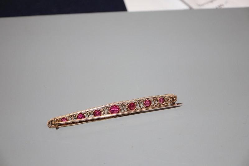 An early 20th century yellow metal and graduated pink tourmaline set bar brooch, 82mm, gross 6.4 grams.
